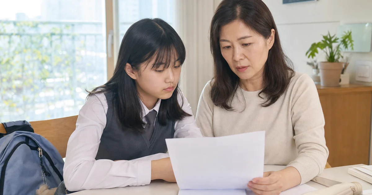중학생 자녀와 교육급여 지원 서류를 확인하는 40대 보호자